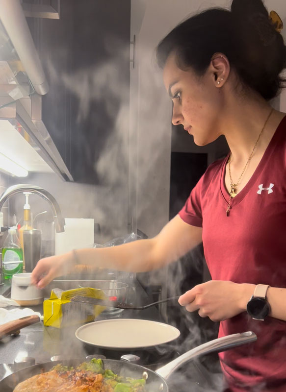 The coach works in a kitchen cooking a meal.